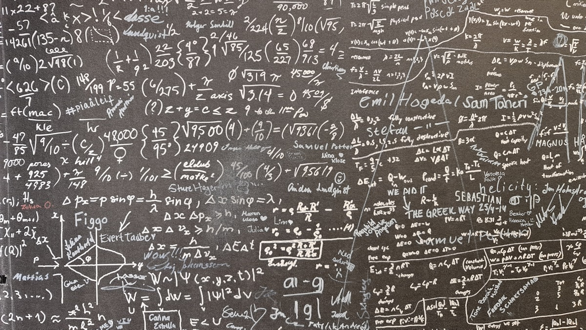 Büyük, koyu renkli bir duvar, farklı karmaşıklık düzeylerinde yoğun bir şekilde yerleştirilmiş el yazısı matematiksel denklemler ve hesaplamalarla kaplıdır.